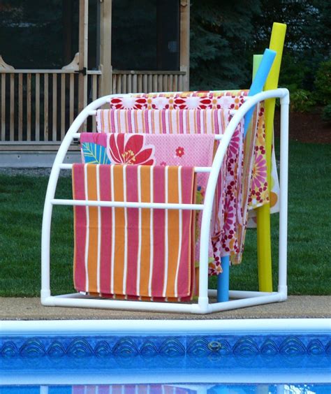 Two Towels Are Hanging On A Rack Next To A Swimming Pool