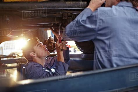 Mechanics Working Under Car In Auto Repair Shop Stock Photo Dissolve