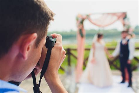 Wedding Photographer Takes Pictures Of Bride And Groom In City Wedding