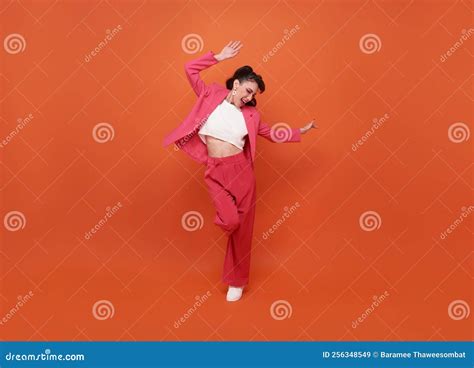 Happy Young Beautiful Woman Dancing Isolated On Orange Background In