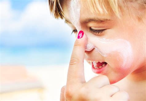 Applying Sunscreen To Childs Face On Beach Stock Photo Download Image