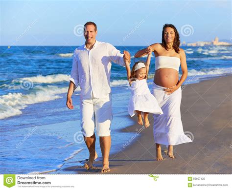 Familia Feliz En Caminar De La Arena De La Playa Imagen De Archivo