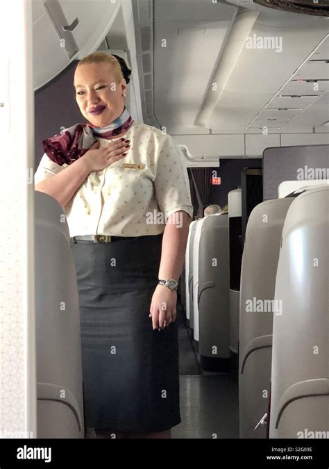 A Senior Flight Attendant Saying Thanks With Her Hand On Her Heart With Gratitude To Passengers