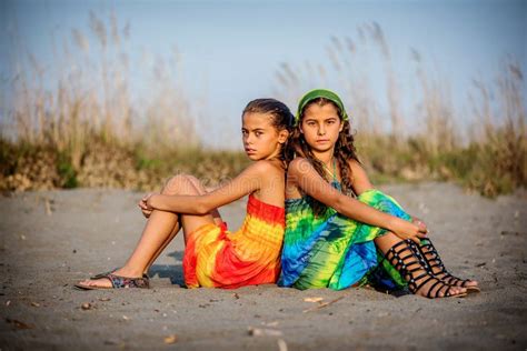 twee mooie jonge meisjes die op het strand zitten stock foto image of twee mooi 129727182