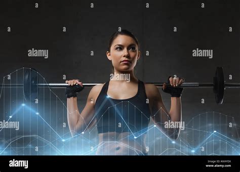 Young Woman Flexing Muscles With Barbell In Gym Stock Photo Alamy