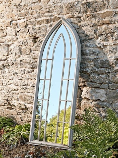 A Large Mirror Sitting On Top Of A Stone Wall