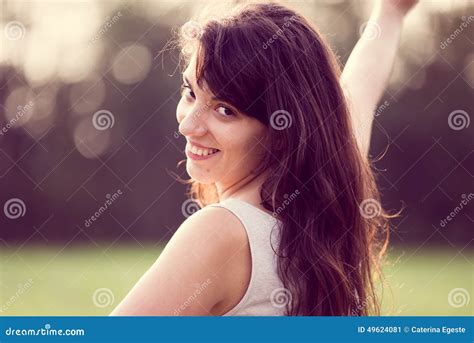 schönes glückliches lächelndes mädchen mit dem langen schwarzen haar in einem garten stockbild