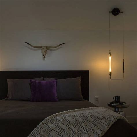 A Bed With Two Lights On Each Side And A Cow Skull Mounted To The Wall