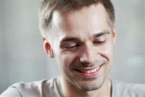 Young Man Looking Down And Smiling Close Up Stock Photo Dissolve
