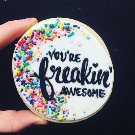 A Hand Holding A Decorated Cookie With The Words Youre Freaking