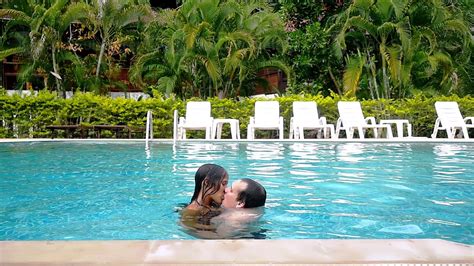Young Couple Kissing In The Swimming Pool On Their Vacation Slow