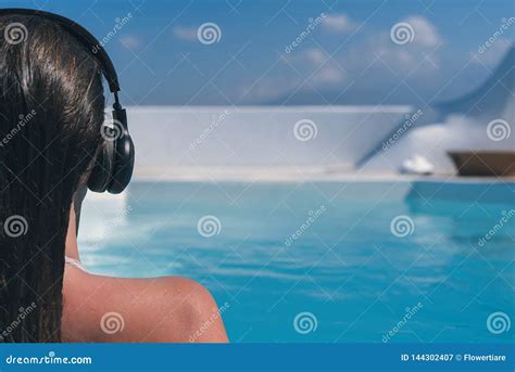 woman in the headphones listening to the music bathing in a pool imagem de stock imagem de