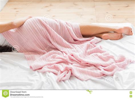 Woman Covered By Pink Blanket Lying On Bed Sideview Stock