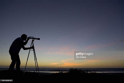 Silhouette Of Man Using Telescope At Dusk Side View High Res Stock