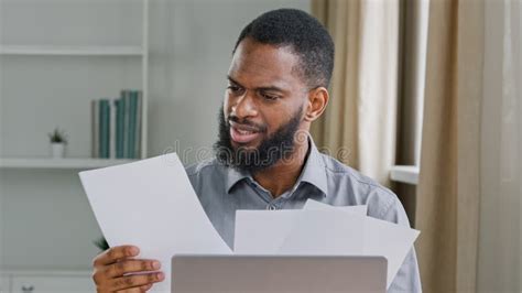 Overworked Millennial Ethnic Male Office Worker Stressed By Paperwork