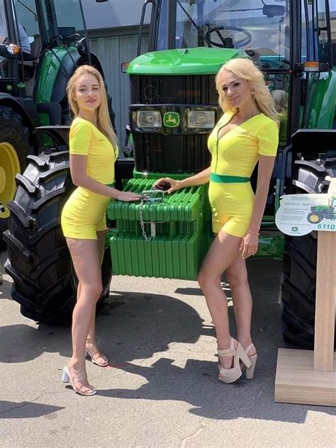 Two Beautiful Women In Yellow Dresses Standing Next To A Large Green