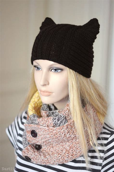 A Female Mannequin Wearing A Black Knitted Hat And Scarf With Cat Ears