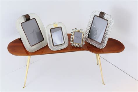 With an included open shelf and drawer under the table's surface, this table provides extra storage for magazines, table books, remotes, and more for easy organization. Wooden Freeform Coffee Table with Brass Legs • Cupio Gallery