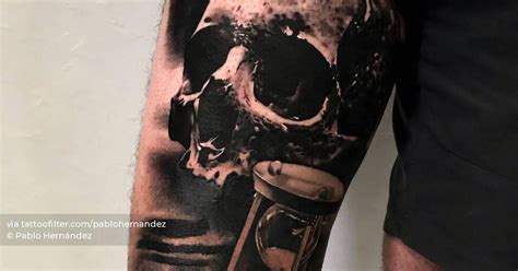 Black And Grey Skull And Hourglass Tattoo On The Thigh