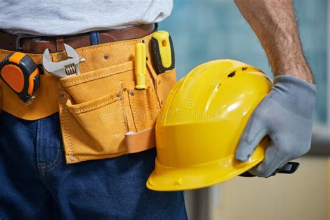 Close Up Of Repairman Wearing A Tool Belt With Various Tools Holding A