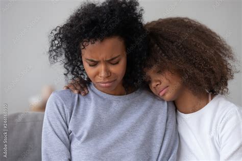 african american teenage daughter hug sad depressed mom crying having life problems caring