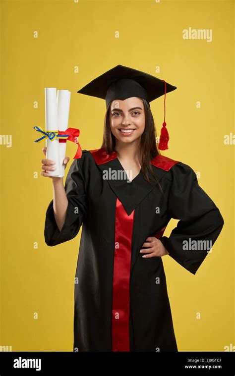 Front View Of Pretty Female Graduate Standing Holding Two Diplomas