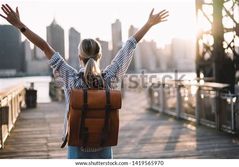 Back View Of Accomplished Tourist Woman With Trendy Backpack And Raised