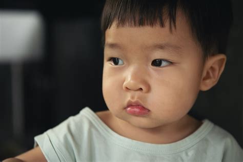 Niño De Niños Asiáticos Haciendo Pucheros Y Fruncir El Ceño En Negro