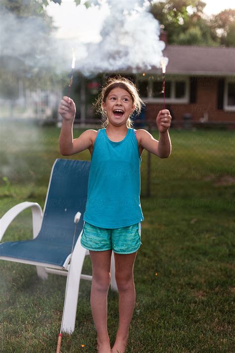 Smiling Tween Girl Holding Sparklers In Backyard By Stocksy Contributor Amanda Worrall Stocksy