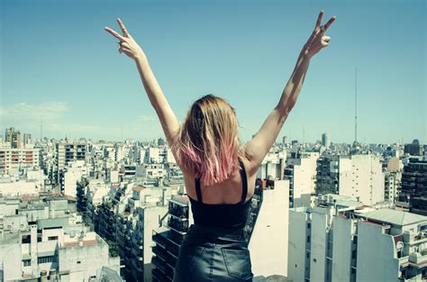 Free Photo Woman Standing On Rooftop Putting Hands In The Air Under