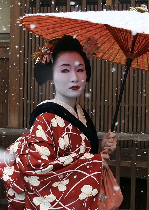 A Maiko A Traditional Japanese Dancer Walks In The Snow In Gion