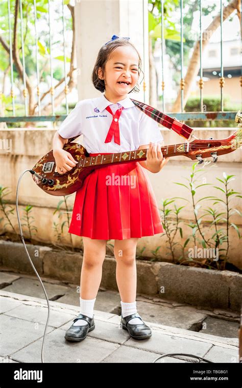 A Cute Little Thai Girl Performs To The Public By Playing Her Guitar In