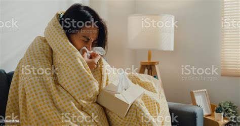 Sick Young Asian Woman Blowing Nose And Sneeze With Tissue Paper