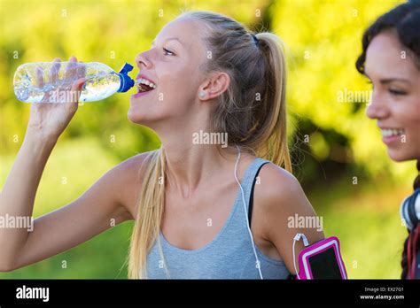 Outdoor Portrait Of Running Girl Drinking Water After Running Stock