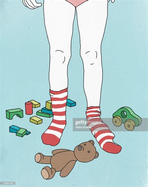 Low Section Of Girl Wearing Socks While Surrounded By Toys Against