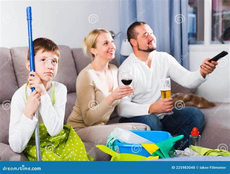 Sad Boy Tired After Cleaning With Carefree Parents Stock Photo Image