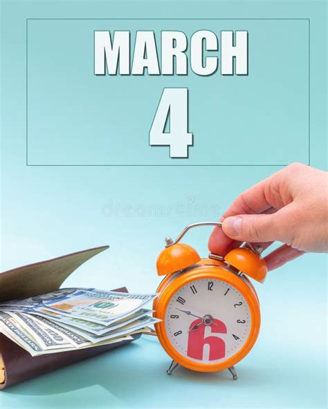 March 4th Hand Holding An Orange Alarm Clock A Wallet With Cash And A