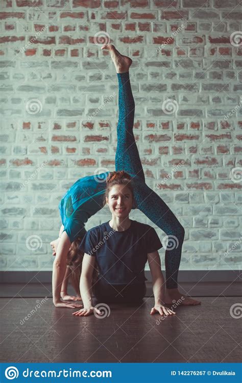 Two Women Doing Partner Yoga In Yoga Studio Opposite Brick Wall Stock Image Image Of Couple