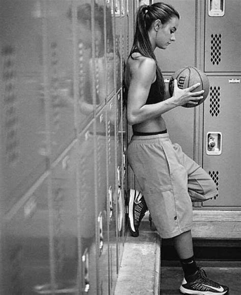 A Woman Leaning Against A Locker Holding A Basketball