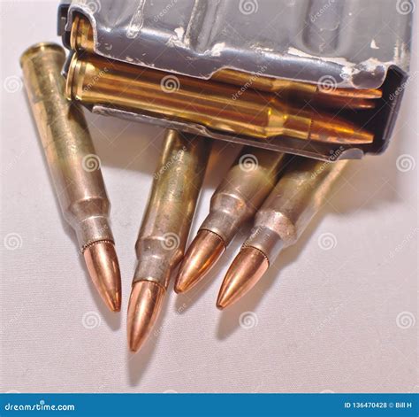 A Loaded Ar 15 Rifle Magazine On Top Of Four 223 Caliber Bullets Stock