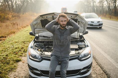 Young Upset Casual Man Trying To Fix His Broken Car Outdoors Man