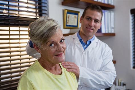 Physiotherapist Stretching Neck Of A Female Patient Stock Photo Image