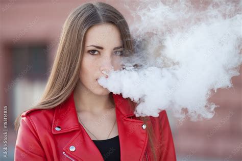 Vaping Young Beautiful Woman Smoking Vaping E Cigarette With Smoke Outdoors Vapor Concept