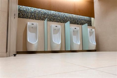 uma fileira de urinóis na parede de azulejos em um banheiro público banheiro vazio foto premium