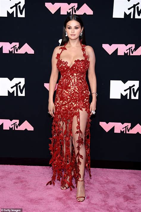 selena gomez is red hot in a low cut floral gown with a sizzling thigh high slit as she attends