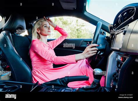 Beautiful Fashionable Woman Blonde Driver Behind The Wheel Of A Car