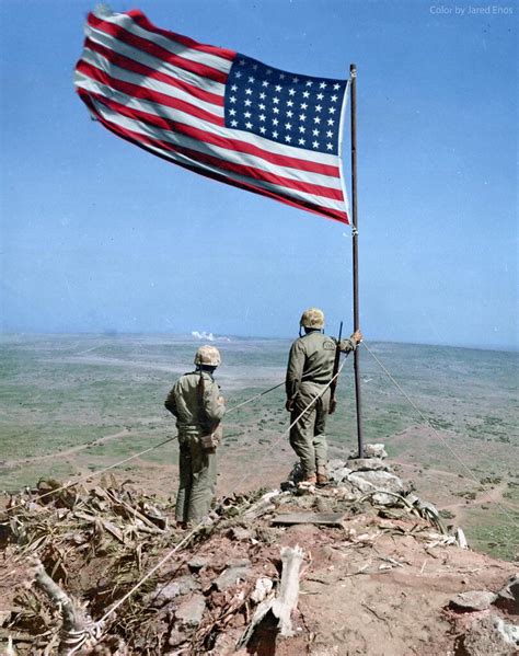 Two Us Marines Stand Atop Mt Suribachi Overlooking The Remainder Of