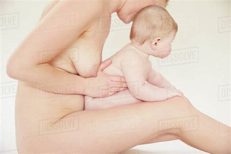 Naked Mother Bonding With Naked Baby On Lap Stock Photo Dissolve