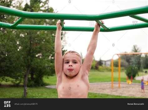 Boy Playing On Monkey Bars At A Park Stock Photo Offset