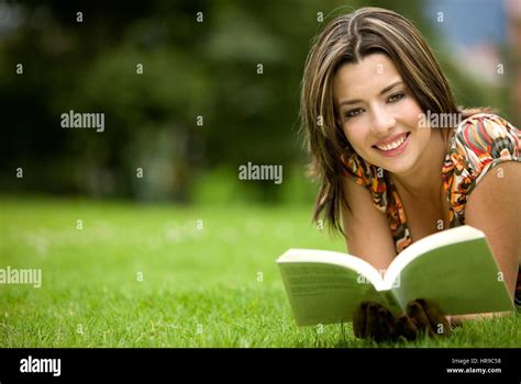 Beautiful Girl Reading A Book Lying On The Floor Outdoors Stock Photo